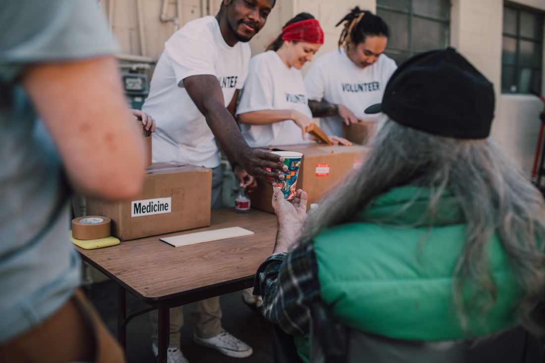 Volunteers handing out support and food to people at an outdoor community event