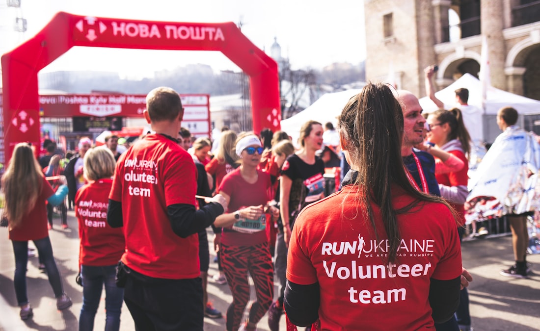 Volunteers in bright shirts supporting participants at a busy community event