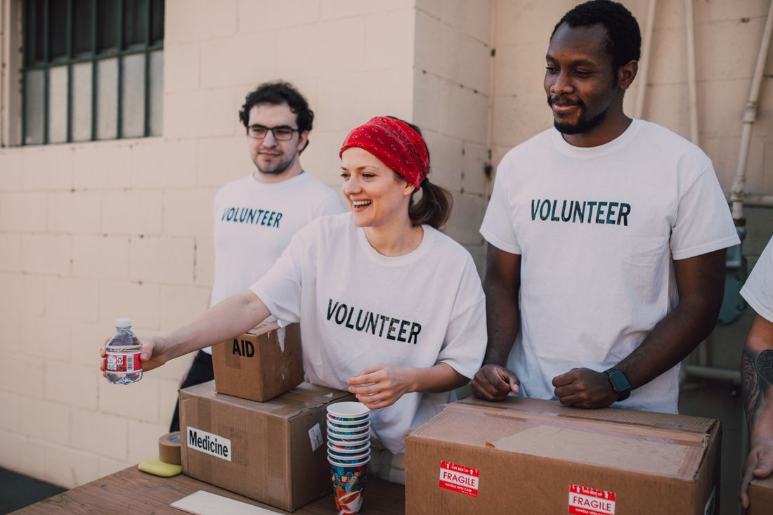 Community volunteers in matching shirts distributing supplies at a donation point